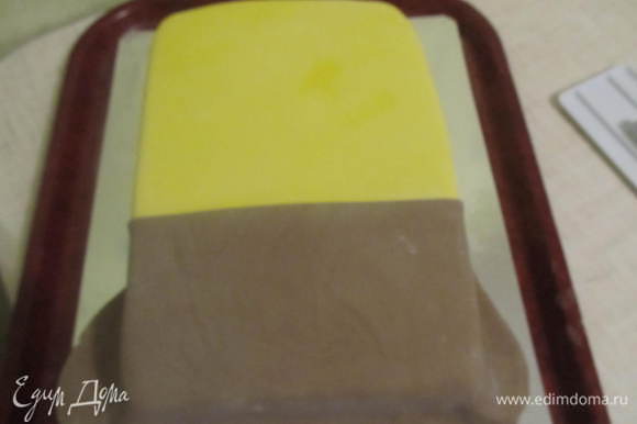 После того как тортик хорошо выровняли можно приступать и к украшению. Раскатать желтую мастику и накрыть им половину тортика (желательно больше половины). Вторую половину (поменьше) покрыть коричневой мастикой. Чтобы место стыка 2-х цветов было ровное, перед покрытием с одного края, надо отрезать ровненькую линию.