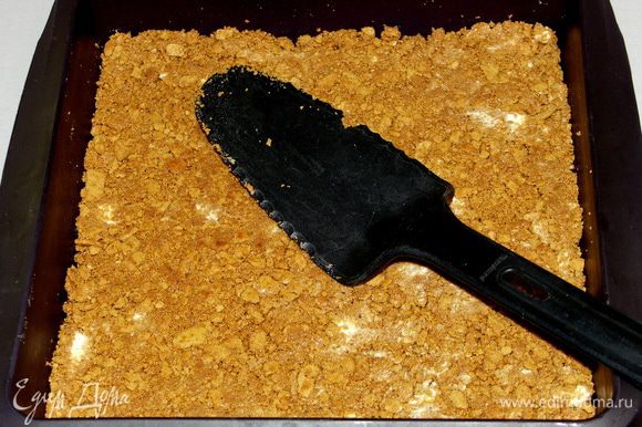 Печенье утрамбовать в силиконовую форму плоской лопаточкой в равномерный слой.Поставить форму на доску разделочную и убрать на 15-20 мин в морозилку.Духовку разогреть до 170С.