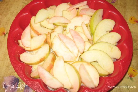 На сахар кладем яблоки, порезанные дольками.