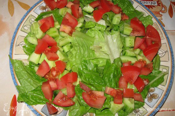 В тарелку порвать листья салата, сверху положить кубики огурца и помидора,посолить по вкусу.