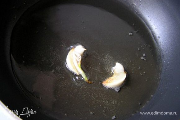 Картофель вымыть со щеткой, нарезать кружочками, толщиной около 3-5 мм. Разогреть половину растительного масла, очистить чеснок, разрезать вдоль на 2 половинки и обжарить 1-2 минуты до румяности. Выложить в миску.