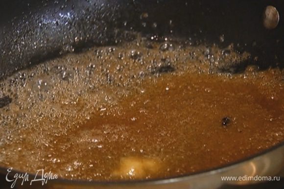 Разогреть в тяжелой сковороде сливочное масло, всыпать оставшийся сахар и дать ему раствориться.