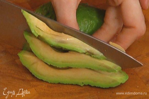Авокадо очистить от кожуры, удалить косточку и нарезать тонкими дольками.