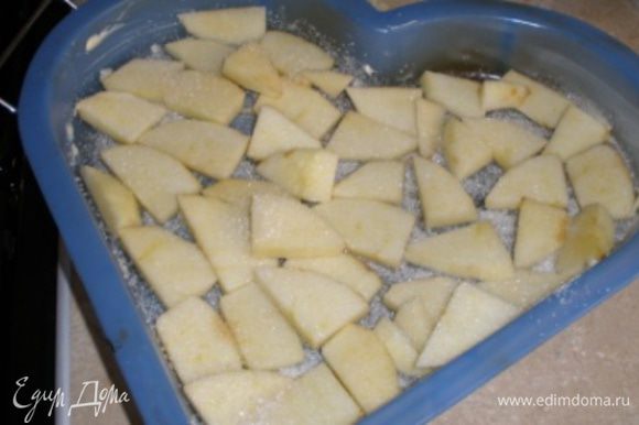 Форму для выпечки смазать сливочным маслом и посыпать сахаром. Яблоко очистить от кожуры, порезать на тонкие ломтики. Выложить яблоко на форму и посыпать сахаром.