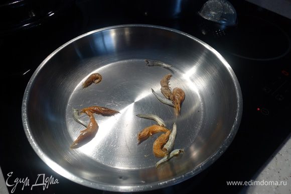В течение 30 секунд обжариваем на сухой сковороде креветки и анчоусы.