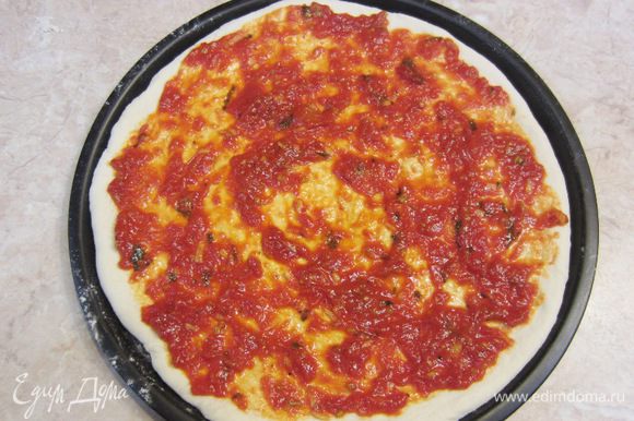 Выложите третью часть соуса посередине пиццы и распределите его так, чтобы по краям пиццы осталось свободное пространство около сантиметра.