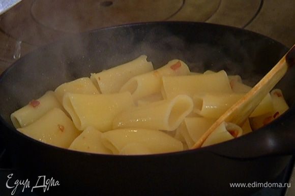 Выложить макароны в сковороду с беконом, перемешать и слегка остудить.
