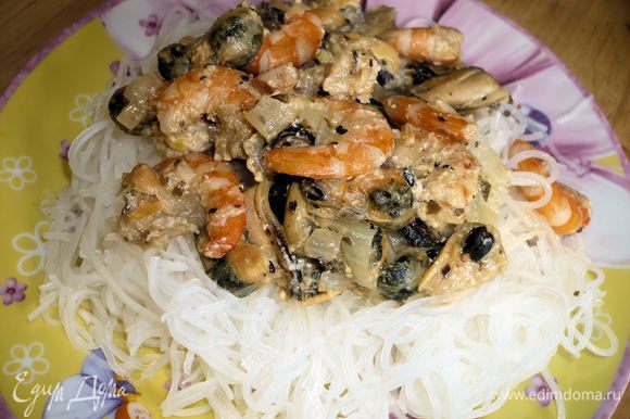 На рисовую лапшу выложить морепродукты, при желании можно посыпать сверху тертым сыром