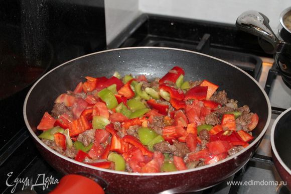в это время,нарезаем перцы и помидор кубиками,и добавляем к обжареному мясу