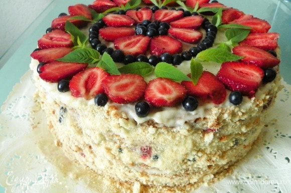 Оставшийся крем распределяем на верхний корж и на бока торта. Украшаем торт сверху ягодами, листиками мяты. Бока по желанию можно обсыпать крошками от коржей или оставить просто белыми.