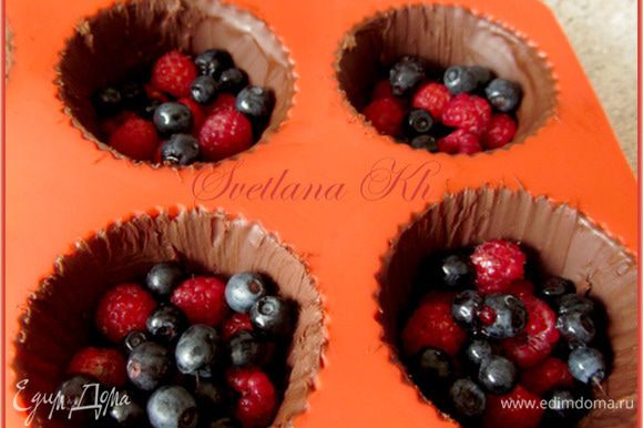 Достать шоколадные корзинки из формочек. Насыпать туда ягод, сверху - сливочный крем. Украсить ягодами и мятой.