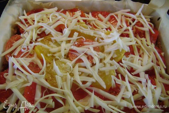 Вынуть форму из духовки, сверху разложить кружочки помидоров и посыпать оставшимся сыром. Выпекать в духовке ещё 20 мин.
