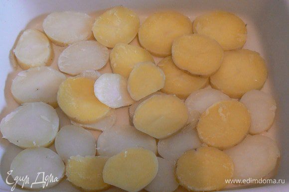 Отварить молодой картофель, можно в мундире. Дно формы смазать маслом. Выложить по дну порезанный кружочками картофель
