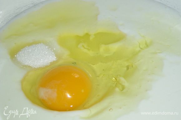 В кефир добавьте одно яйцо, сахар, соль и растительное масло, хорошо перемешайте.
