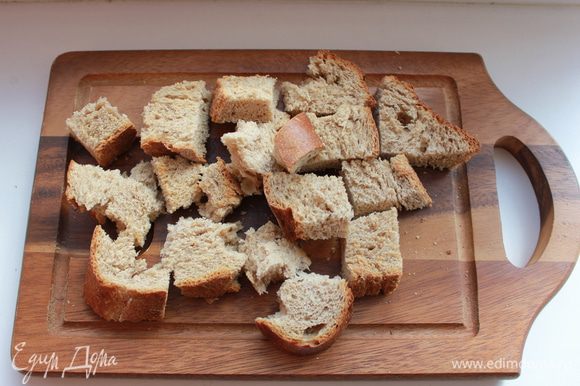 Нарезать крупными кубиками хлеб и залить его мясным бульоном.