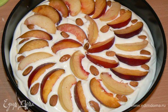 Сверху разложить дольки персиков и посыпать орехами. Поставить персиковый пирог в духовку на 45-50 минут при 170 градусах