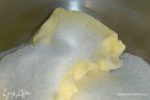 Начинка готова, и мы приступаем к приготовлению коржей. Размягченное масло взбиваем до бела с сахаром, а затем по одному добавляем яйца и взбиваем до однородного состояния.