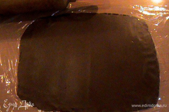 Раскатать шоколадный шар в прямоугольник толщиной 2-3мм. Удобнее всего раскатывать это тесто между пищевой плёнкой. Так оно не прилипает к скалке.