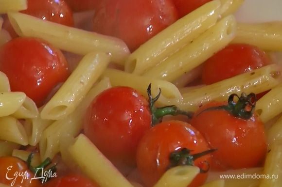 Отваренные макароны слить, сбрызнуть оставшимся оливковым маслом, добавить запеченные помидоры и все перемешать.