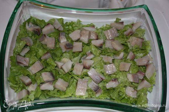 Выкладываем кусочки селедки на салат.