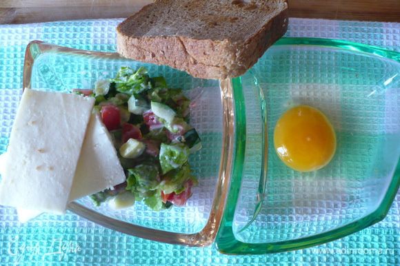 Хлеб подсушить в тостере. Мелкими кубиками нарезать огурчик, помидорку и листья салата. Овощи смешать с соусом «цезарь».