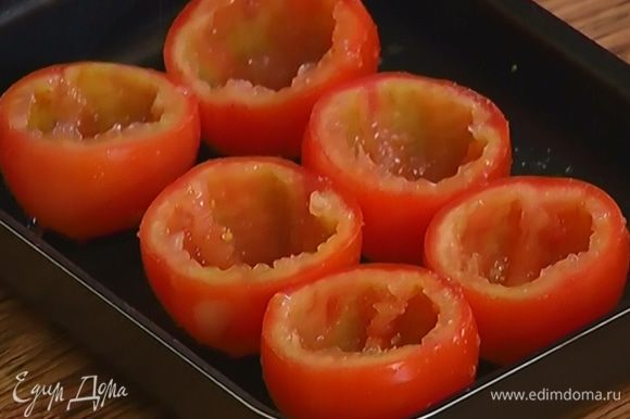 Поместить «чашечки» помидоров в небольшую форму для выпечки, посолить и поперчить их.