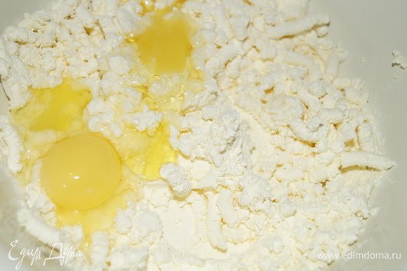 Творог смешайте с яйцами, сметаной и сахаром. Мешайте до растворения сахара.