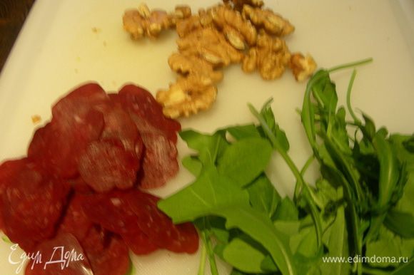 Для салата мелко режем руколу, вяленое мясо и грецкие орехи.