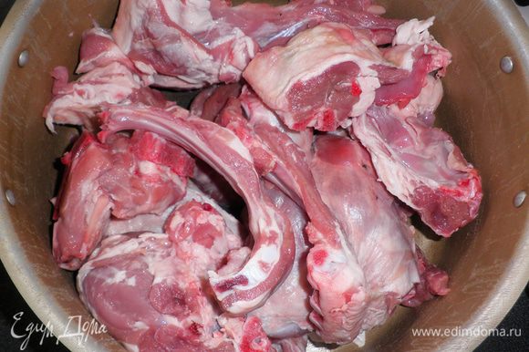Нарезать мясо барашка на порционные куски и уложить в большую кастрюлю.