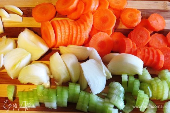 Зубчики чеснока раздавить плоской стороной ножа.Морковь и сельдерей нарезать кружочками. Луковицу разрезать на 4 части.