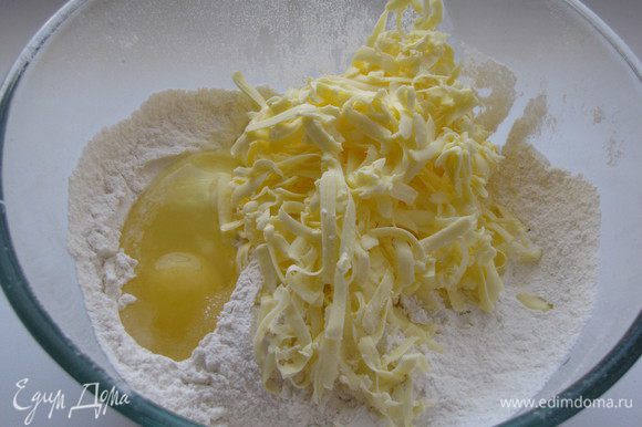 Натереть сливочное масло на крупной терке и смешать с мукой, яйцом, сахарной пудрой, ванилином и разрыхлителем.