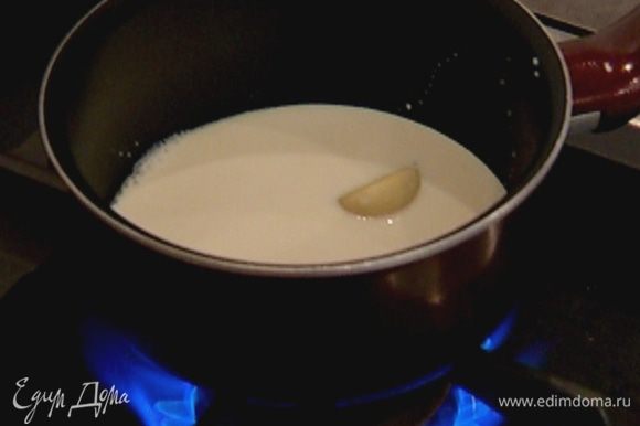 Приготовить соус: молоко и сливки влить в небольшую кастрюлю и, добавив чеснок, довести до кипения, затем чеснок вынуть.
