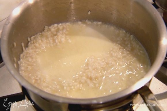 Когда рис станет прозрачным, убавить огонь и вливать небольшими порциями сладкое молоко, давая ему полностью впитаться в рис. Готовить 12–15 минут, почти до готовности риса.