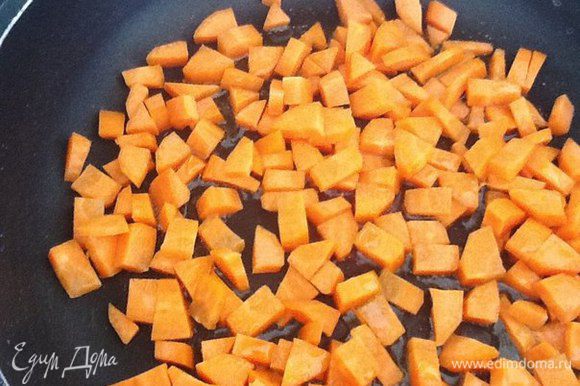 Режем кубиками морковь и выкладываем ее в сковороду