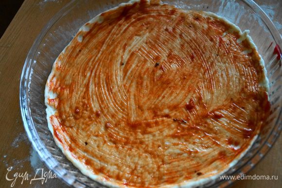 Выкладываем раскатанное тесто в форму для выпечки и смазываем томатной пастой (кетчупом)