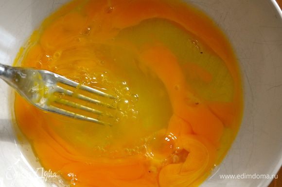 Разбить в миску три яйца и размешать вилкой. Добавить к яйцам половину лука.