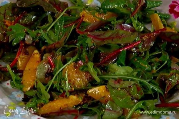 Полить салатные листья с апельсином заправкой, перемешать и выложить на тарелки.