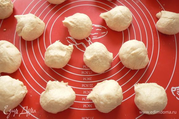выброженное тесто разделить на 16-20 булочек, уложить на бумагу для выпечки, накрыть пленкой, оставить на 40 мин для расстойки