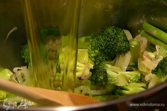 Отправить брокколи и спаржу в кастрюлю с луком и чесноком, перемешать и залить горячим овощным бульоном, так чтобы все овощи были покрыты.