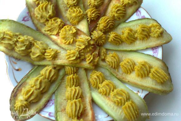 Выложить обжаренные кабачки на большую тарелку в виде цветка и украсить лепестки хумусом.