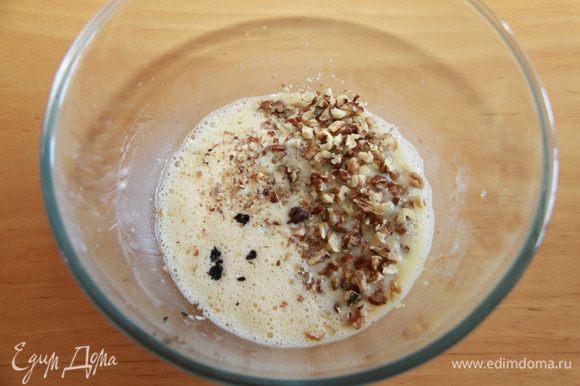 В миске взбейте рапсовое масло и яйца вместе, пока не смешаются. Добавьте ваниль и одну чашку нарезанных орехов.