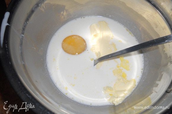 В другую миску к сливкам, перемешанным с водой, добавить сахар, яйцо, 70 г размягченного сливочного масла и хорошо перемешать.