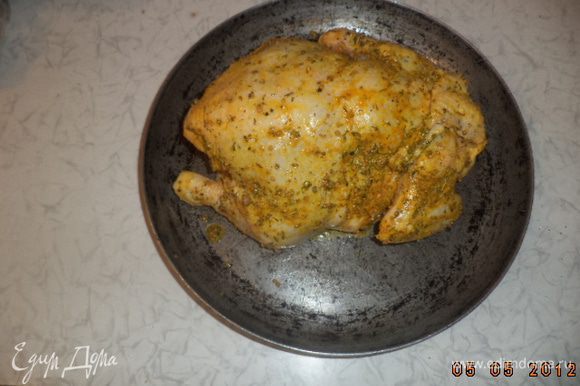Запекать курицу при температуре 200 градусов около часа до румяной корочки, поливая её образующимся соком.