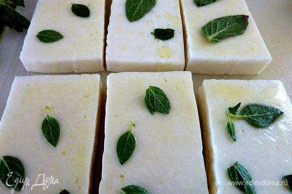 Кисточкой помазать сыр с оливковым маслом и посыпать листьями орегано. Смажьте сковороду тоже с оливковым маслом.