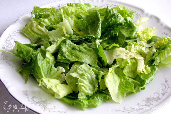 В тарелку выложить салатные листья.