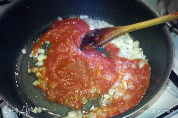 К луку добавить томатную пасту и перемешать