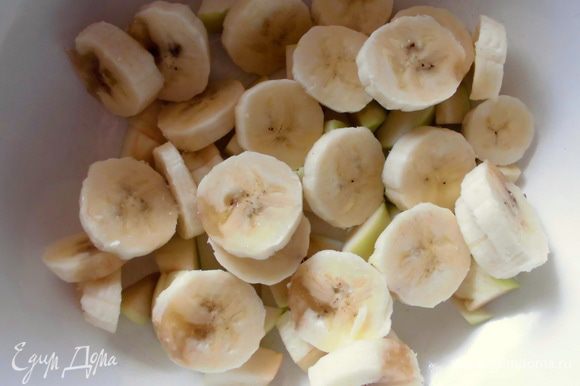 Из яблока удалить сердцевину и нарезать довольно крупными кусочками. Банан нарезать ломтиками и добавить в миску к яблоку.