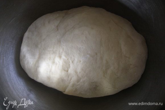 Постепенно добавляя муку, замесить мягкое и эластичное тесто. Затем немного смазать миску растительным маслом, положить готовое тесто и оставить подходить в теплом месте 1,5–2 часа.