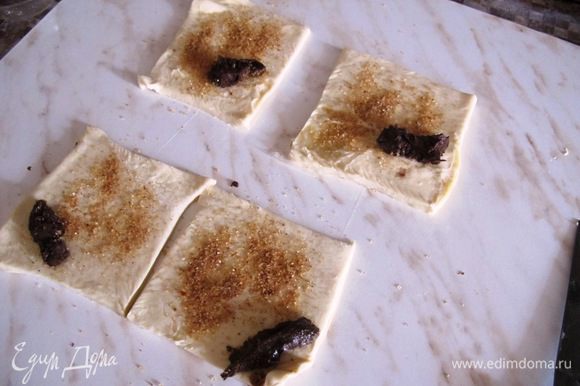 Нарежьте тесто на квадратики, посыпьте смесью корицы и сахара, и положите на уголок ложечку пасты.