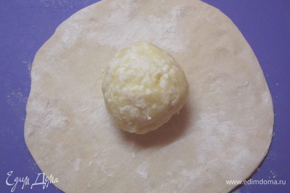 Разделить тесто на кусочки. Каждый кусочек раскатать в небольшую лепешку. В центр лепешки выложить сырно-картофельный шарик. Края теста собрать сверху.